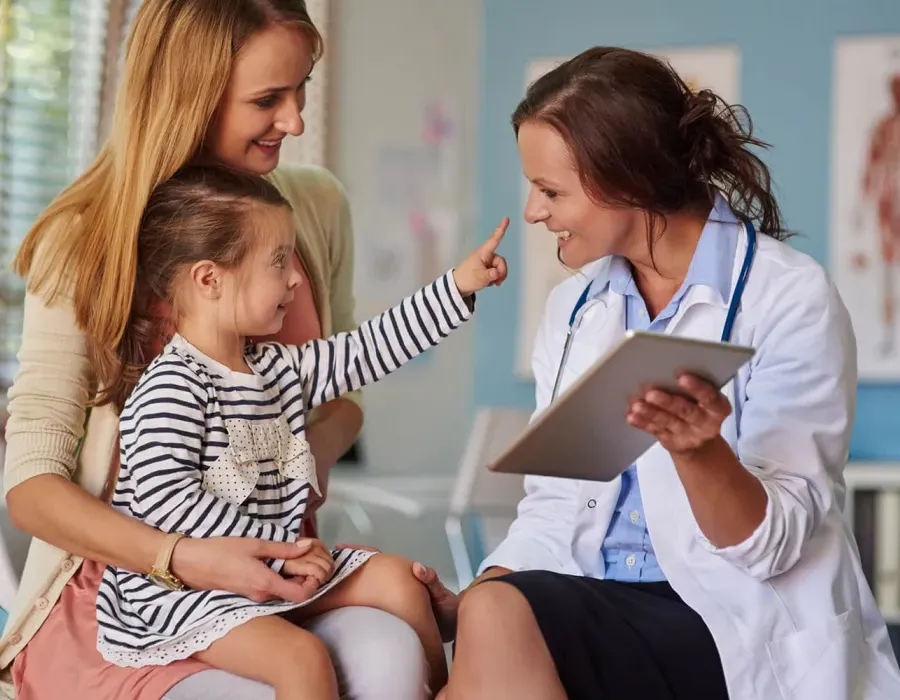 Pediatric Nurse Practitioner Smiling with Young Patient During Exam